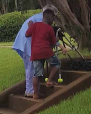Young boy helps an elderly woman climb stairs