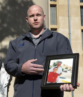 gbs111815r/ASEC -- Ken Wolter of Detroit, Michigan, a New Mexico survivor of childhood sexual abuse by Catholic Priests, at a press conference on Wednesday, November 18, 2015. Wolter holds a picture of when he was a child, and the priest, Art Perrault, who abused him. (Greg Sorber/Albuquerque Journal)