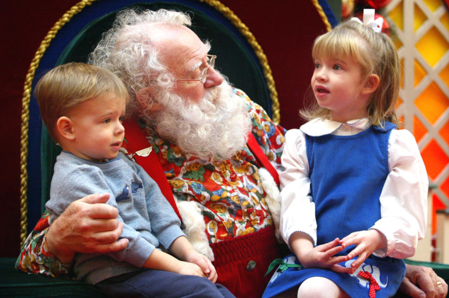NILES, IL - DECEMBER 19: Sporting a natural white beard, Santa Claus visits with Ian, 2, and sister Devin Rachiele, 4, December 19, 2003 at Golf Mill Mall in Niles, Illinois.  Santa says that the children that visit him feel more comfortable when he is not wearing his traditional Santa coat and hat. (Photo by Tim Boyle/Getty Images)